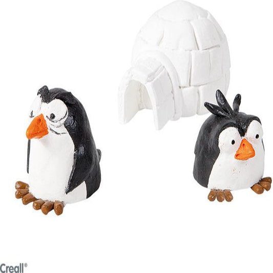 Two penguin figurines with a small igloo on a white background