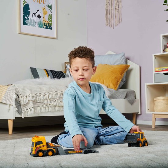 Child playing with toy trucks in a bedroom