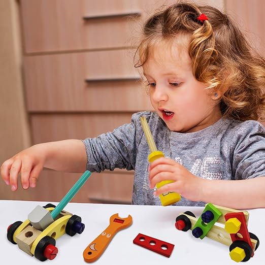 Child playing with toy tools and cars on a table