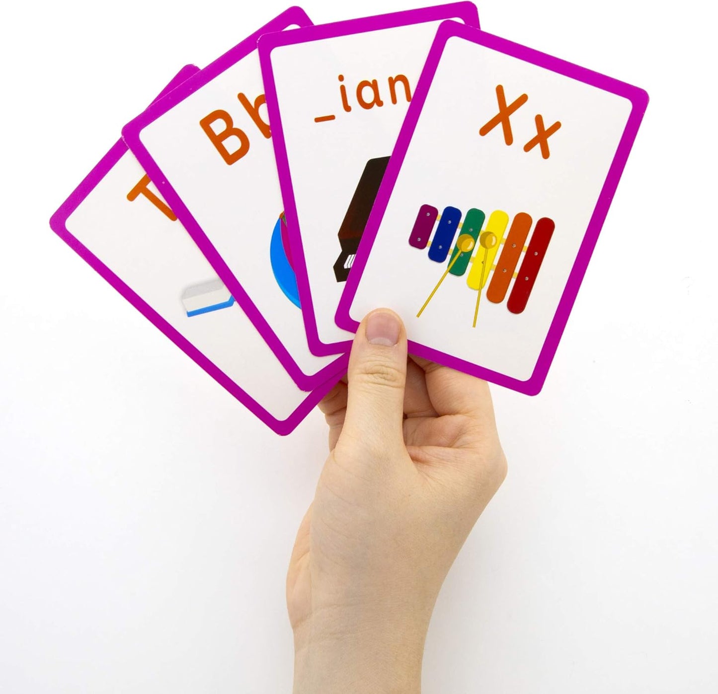 Hand holding educational flashcards with letters and symbols on a white background