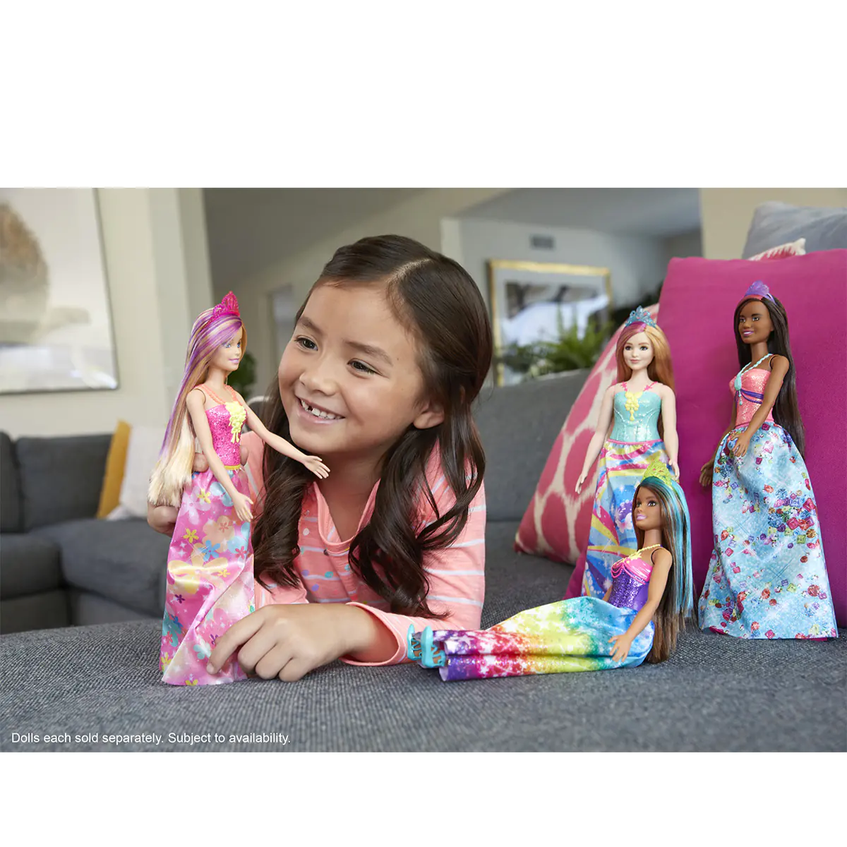Young girl playing with Barbie dolls in a living room setting