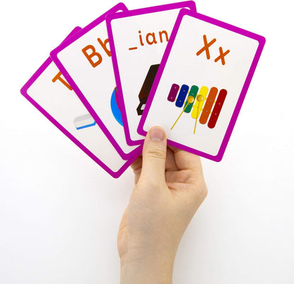 Hand holding educational flashcards with letters and symbols on a white background